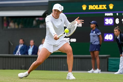 Iga Swiatek plays a backhand return to Petra Martic